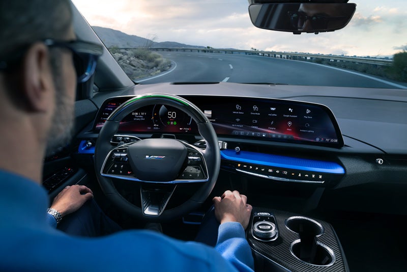 Front View of the 2026 OPTIQ-V Driving Through the Dusk Utilizing its Headlights | Bergstrom Cadillac of Appleton in Appleton WI