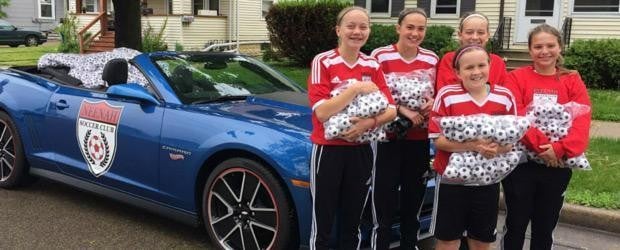 soccer team holding mini soccer balls